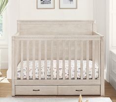 a baby crib with two pictures on the wall