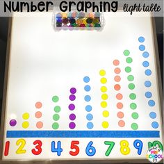 a number graphing light table with colored dots on it and numbers in the background