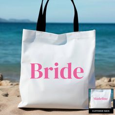 a white tote bag sitting on top of a sandy beach