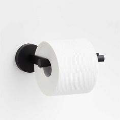 a black and white toilet paper holder on the wall with a roll of toilet paper in it