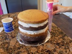 a cake sitting on top of a counter next to a cup