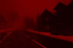 a red foggy street with houses and trees