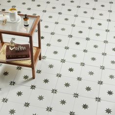 a coffee table with two books on it in front of a star patterned wallpaper