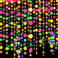 an abstract background with multicolored circles hanging from it's sides and lights in the background