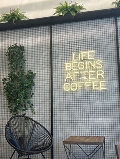 a chair and table in front of a wall that says life begins after coffee