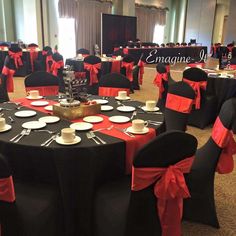 a banquet room set up with black and red linens