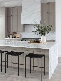 a kitchen with marble counter tops and stools