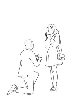 a man kneeling down next to a woman who is holding a small object in her hand