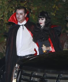 a man and woman dressed up as dracula and vampire bride walking down the street at night