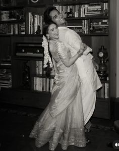 black and white photograph of two women hugging each other in front of bookshelves