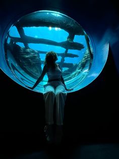 a woman standing in front of an aquarium tank