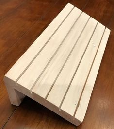 a wooden bench sitting on top of a hard wood floor