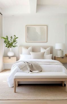 a bedroom with white bedding and neutral decor