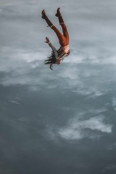 a man falling into the water with his feet in the air