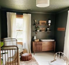 a baby's room with a crib, dresser and bed in it that has white drapes on the windows