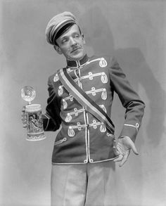 an old photo of a man in uniform holding a beer