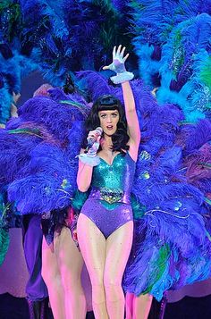 a woman in a purple and green costume on stage