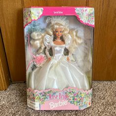 the barbie bride doll is in its box on the floor next to a wooden door