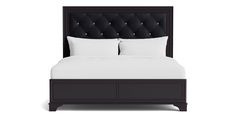 a bed with white sheets and black headboard on it's side, in front of a white background