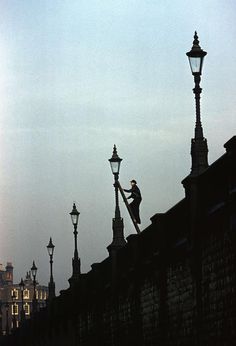 a man is on top of a lamp post