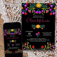 an image of a black and white wedding card with colorful flowers on the front, next to a cell phone