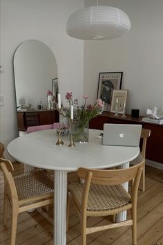 a white table with two chairs around it and a laptop on top of the table