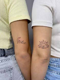 two people with matching tattoos on their arms, one is holding the other's arm