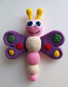 a crocheted butterfly with big eyes on it's back legs and wings