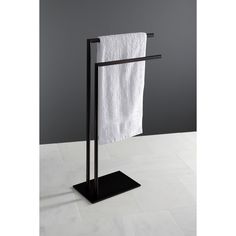 a black towel rack with two white towels hanging from it's sides and a gray wall in the background