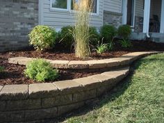 a brick garden bed in front of a house