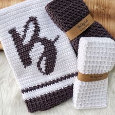 a crocheted dishcloth with a brown and white design on it, next to a pair of knitted mitts