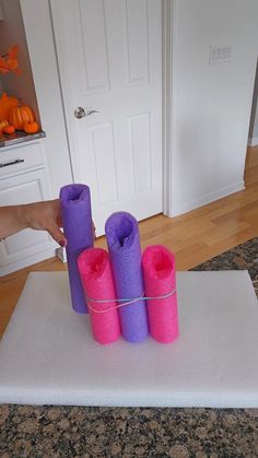 purple and pink candles are tied to a white mat