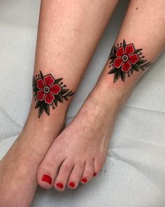 two feet with red flowers on them and one has black dots around the toe area