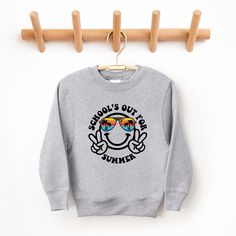 Looking for a cute sweatshirt for your kids? We have the perfect School's Out Smiley Face graphic sweatshirt addition to their closet! Also available in toddler sweatshirts. Cartoon Print Long Sleeve Sweatshirt For School, Cute Crew Neck Sweatshirt For School, Fun Cartoon Print Sweatshirt, Cute Letter Print Sweatshirt For School, School Crew Neck Sweatshirt With Graphic Print, Fun Cotton Slogan Sweatshirt, Fun Cotton Sweatshirt With Slogan, Long Sleeve Sweatshirt With Text Print For School, Smiley Face Graphic