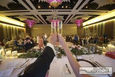 a person holding up a wine glass at a wedding reception