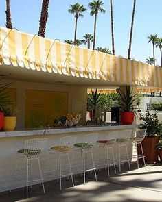 an outdoor bar with lots of plants and chairs