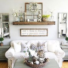 a living room filled with white furniture and lots of decor on top of the walls