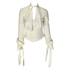 Presenting a white cotton Gucci blouse designed by Tom Ford. From the Fall/Winter 2003 collection, this beautiful top features quilted details on the body, creating a corset silhouette. With a plunging neckline, this top has ties that wrap around the neck and wrists. Approximate measurements: Size - IT38 Shoulder to hem: 18" Bust: 34" Waist: 26" Shoulder to cuff: 24.5" Underarm to cuff: 18.5" 78% cotton, 17% nylon, 5% spandex Vintage Tom Ford, Gucci Blouse, Tom Ford For Gucci, Gucci By Tom Ford, Tom Ford Clothing, Carolyn Murphy, Lovely Clothes, Tie Blouse, Work Wardrobe