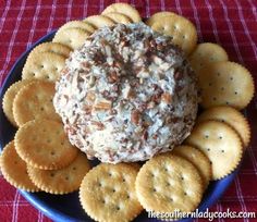 a plate with crackers and a cheese ball on it, surrounded by crackers