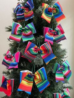 a christmas tree decorated with colorful ribbons and bows