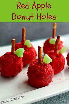 small red apples are on a white plate with toothpicks sticking out of them