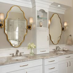 a bathroom with double sinks and two large mirrors on the wall above them is shown