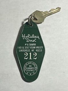 a green keychain with the words holiday inn on it's front and back