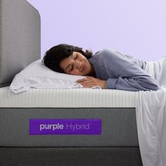 a woman laying on top of a purple hybrid mattress