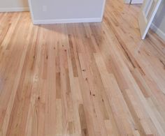 an empty room with hard wood floors and white walls