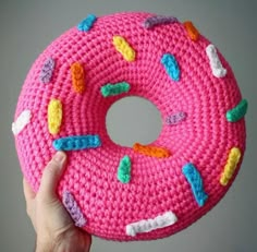 a pink knitted donut with sprinkles on it