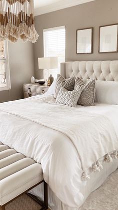 a white bed sitting in a bedroom next to a window