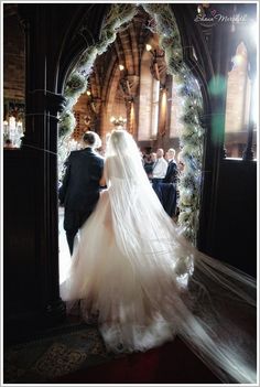 a bride and groom walking down the aisle at their wedding ceremony in an old church