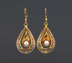 An irradiating piece of jewelry, this earring has: A triple layer teardrop frame with alternating metal/color (brass - copper -brass). A copper base teardrop pendant with a pearl (7 mm) A gold toned brass earwire.  Total length: 62 mm teardrop pendant:  38 x 26 mm center pendant: 20 x 13 mm Pearls : 7 mm If you have questions, please send me a message. Teardrop Metal Pearl Earrings, Teardrop Pearl Earrings In Metal, Teardrop Pearl Earrings With Metal Ear Wire, Pierced Teardrop Pearl Earrings, Metal Teardrop Earrings With Pearl Drop, Metal Teardrop Chandelier Earrings With Pearl Drop, Metal Teardrop Pearl Drop Earrings, Vintage Teardrop Pearl Drop Jewelry, Pearl Drop Teardrop Chandelier Earrings