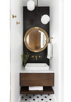 a bathroom with a sink, mirror and black and white floor tiles on the walls